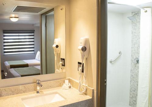 a bathroom with a sink and a mirror at Hotel Calafia in Mexicali