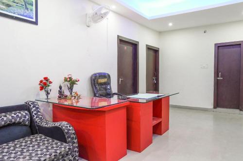 una scrivania rossa con sedia in una stanza di Flagship Aashirwad Guest House a Rānchī