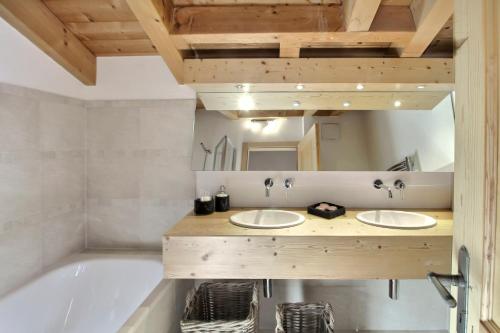 a bathroom with two sinks and a tub at Chalet Les Beliers, The Alpine Chic in Les Crosets