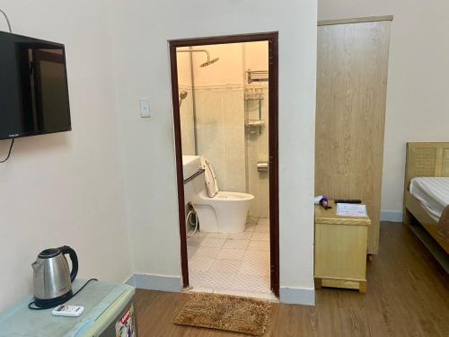 a bathroom with a toilet and a bathroom with a television at Ba Đoàn 2 Hotel in Con Dao