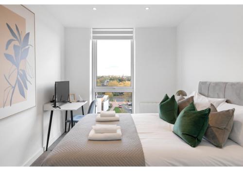 ein weißes Wohnzimmer mit einem Bett und grünen Kissen in der Unterkunft Cosmopolitan Living: Upscale 1BR Gem in Beckenham in Beckenham