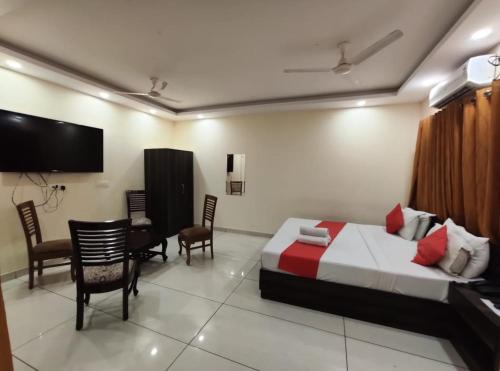 Habitación de hotel con cama, mesa y sillas en OYO Hotel Aerotech, en Nueva Delhi