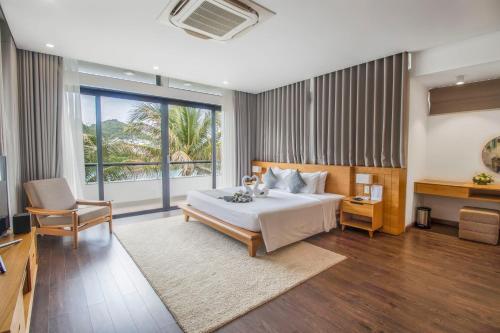 a bedroom with a large bed and a desk and a bed sidx sidx sidx sidx at Champa Island Nha Trang - Resort Hotel & Spa in Nha Trang
