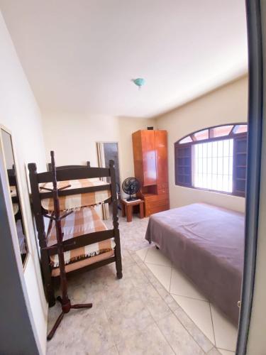 een slaapkamer met een bed en een raam bij Casa em Mongaguá Plataforma in Mongaguá