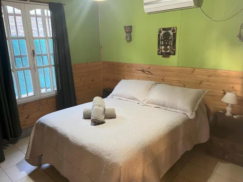 un dormitorio con una cama con un animal de peluche en Cabaña Terra Calma en Vistalba