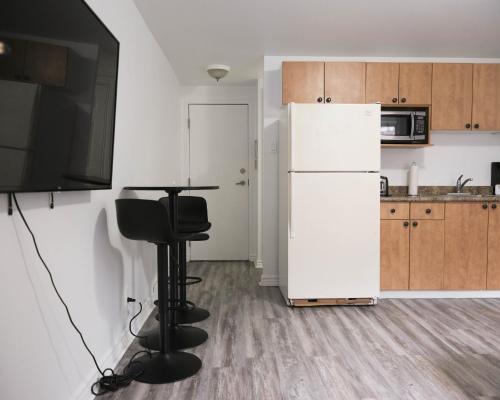 a kitchen with a white refrigerator and a table at Studio apartment with 1 bed - 242 in Montréal