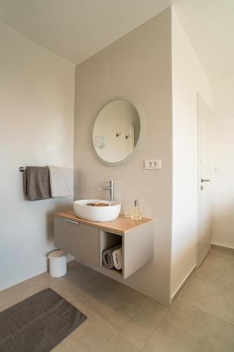 a bathroom with a sink and a mirror at O`Life Boutique Apartments in Vodice