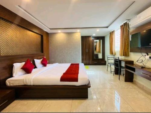 um quarto com uma cama grande e almofadas vermelhas em Yashaswiny recidency em Mysore
