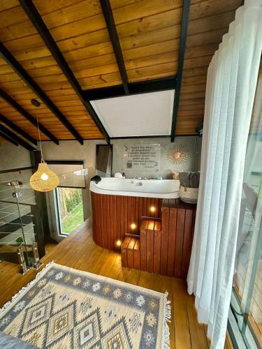 a bathroom with a tub in a room with wooden ceilings at Cabanas Sonho Rosa - com banheira hidro e cesta de café cortesia na primeira manhã in Imbituba