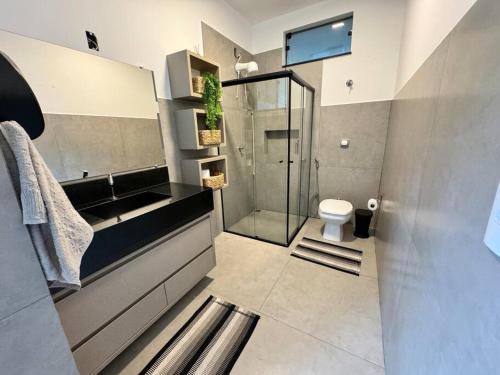y baño con ducha, aseo y lavamanos. en Casa de Campo Monte Sião, en Monte Sião