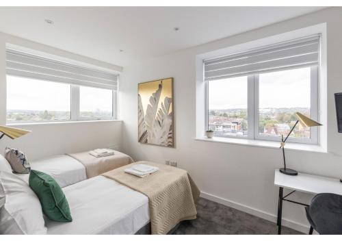 a bedroom with two beds and two windows at Designer Flat in Prime Location in Beckenham