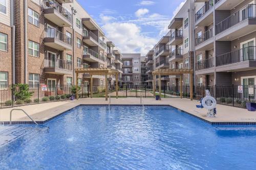 a swimming pool in front of an apartment complex at BRAND NEW Luxurious, Spacious, Gated 2bd Apt in Houston