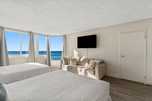 a hotel room with two beds and a television at Top of the Gulf 523 - Beach Front Resort With Ocean View in Panama City Beach