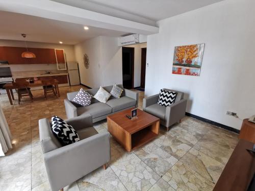 a living room with two couches and a table at Bukit Jaya Residence & Apartment Semarang in Semarang