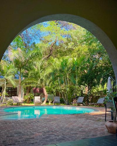 a swimming pool with an arch over it at Jacaranda Lodge in Victoria Falls