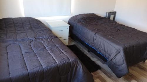 two beds sitting next to each other in a bedroom at Jade 1840 casa completa in San Carlos de Bariloche