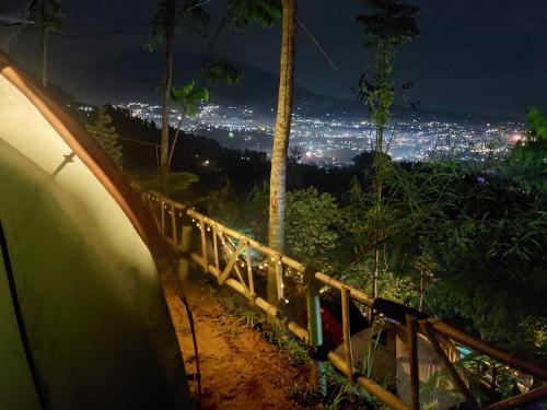 a view of a city at night from a tent at ZOYA HILLS in Pondok Cipaseban
