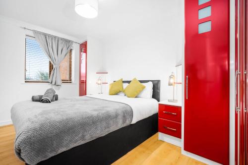- une chambre avec un grand lit et une porte rouge dans l'établissement Comfy 2 bed Apart /free parking/sleeps 4- Oldbury, à Oldbury