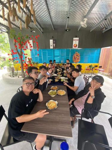 a group of people sitting at a table eating food at Dreamers Farm in Vinh Thanh