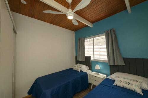 een slaapkamer met 2 bedden en een plafondventilator bij Departamento moderno 6ta sección in La Cieneguita