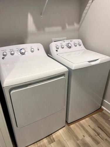 two white appliances sitting next to each other in a kitchen at Cozy Coastal Bungalow in Opelika