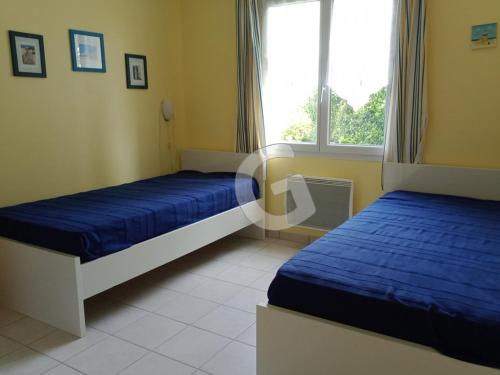 une chambre avec deux lits et une fenêtre dans l'établissement Maison 4 pers avec jardin privé et parking, proche mer - Angles - FR-1-357-6, à Angles