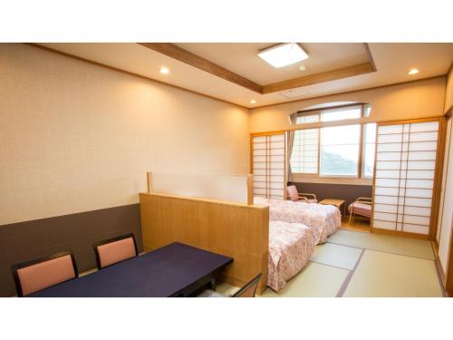 a bedroom with a bed and a table in it at Hotel Keipu - Vacation STAY 11139v in Hakodate