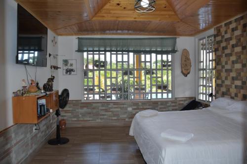 ein Schlafzimmer mit einem Bett und zwei Fenstern. in der Unterkunft Hacienda Mi Rancho in Villavicencio