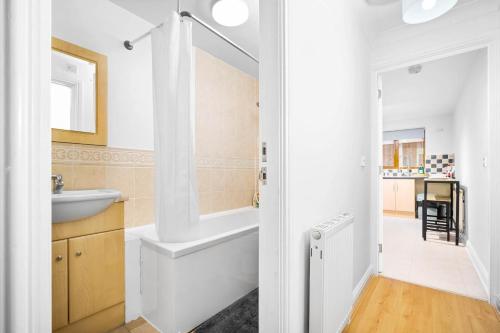 La salle de bains est pourvue d'une baignoire blanche et d'un lavabo. dans l'établissement Comfy 2 bed Apart /free parking/sleeps 4- Oldbury, à Oldbury