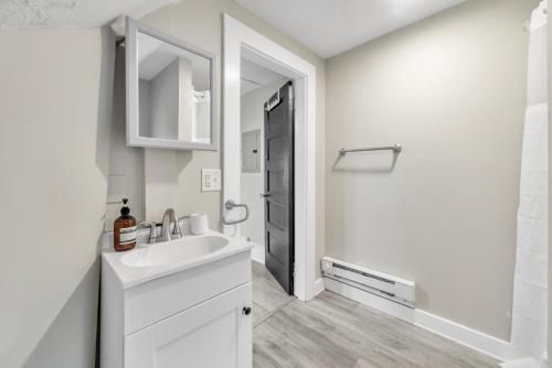 Baño blanco con lavabo y espejo en Beautiful 4BR 2 Bathroom House with Parking, en Springfield