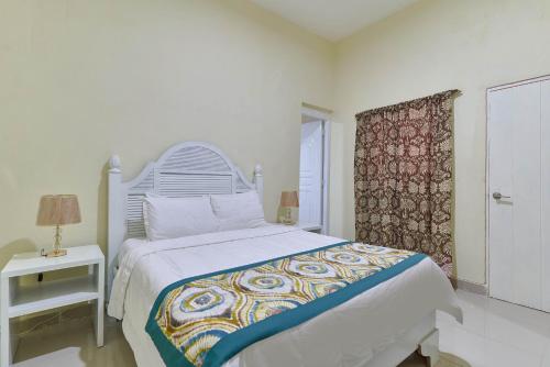 a white bedroom with a bed and a table at Hotel D'Cornelio in Santo Domingo