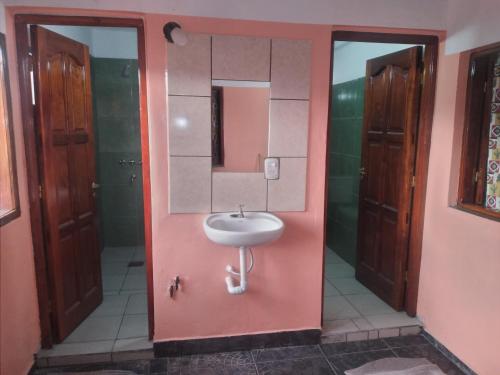 Baño con lavabo en una pared rosa en HOSTAL LUCERO en Humahuaca
