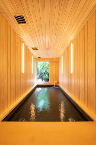 東京にあるCAFE/MINIMAL HOTEL OUR OURの窓のある木造の部屋にある水たまり