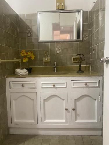 a bathroom with a white sink and a mirror at Depa a unos minutos de consulado! in Hermosillo