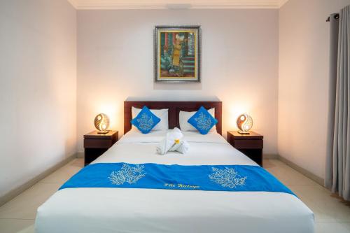 a bedroom with a bed with blue and white sheets at The Kutaya in Kuta