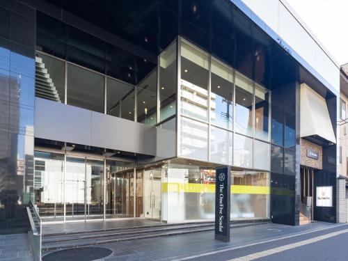 un edificio de cristal con un cartel delante en The OneFive Sendai, en Sendai