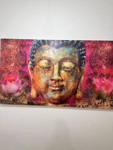 a painting of a buddha with pink flowers at Apartment opera 1 in Vienna