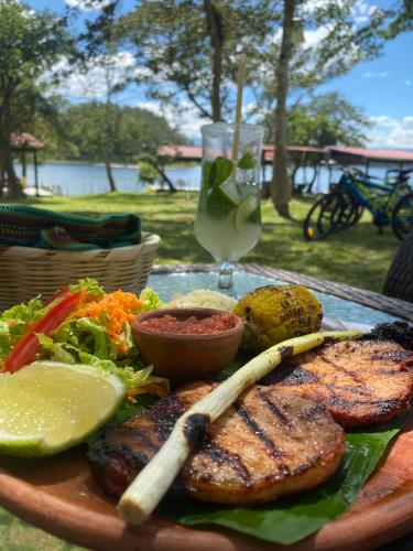 un plato de carne y hortalizas con una copa de vino en Mangoya Lounge 