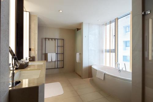 a bathroom with a tub and a sink at Millennium Hotel Taichung in Taichung