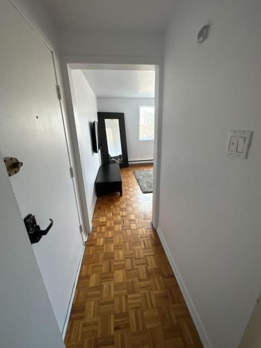a hallway with a room with white walls and a wooden floor at 1 bedroom apartment - 574 in Montréal