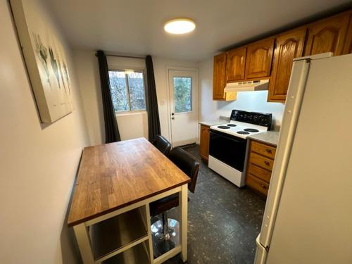 a kitchen with a wooden table and a refrigerator at 1 bedroom apartment - 574 in Montréal