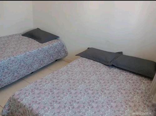 a bedroom with two beds and two rugs at Casa a 5 km de Luziânia 1 quarto com ar-condicionado in Cidade Ocidental