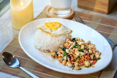 einen Teller mit Reis und ein Ei darauf. in der Unterkunft De Lux Bangkok Hotel in Ban Khlong Lat Bua Khao