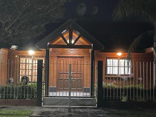 ein Haus mit einem Tor und einem Zaun in der Nacht in der Unterkunft La casa de Cate in Mar de Ajó