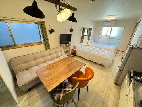 マルチステイ大阪天保山22 في أوساكا: غرفة معيشة مع سرير وطاولة