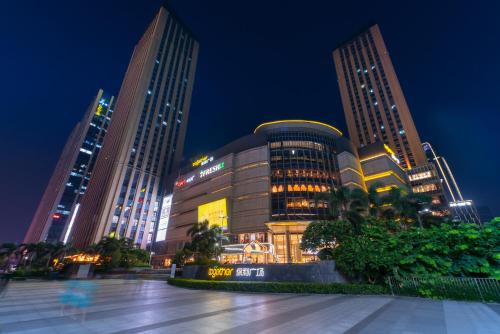 Un grupo de edificios altos en una ciudad por la noche. en Livetour Hotel Pazhou Exhibition Center Guangzhou, en Guangzhou