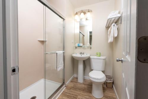 a bathroom with a toilet sink and a shower at Scotty's Lakeside Resort in Lake George