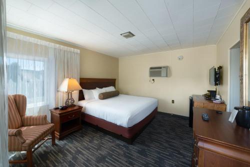 um quarto de hotel com uma cama e uma cadeira em Scotty's Lakeside Resort em Lake George