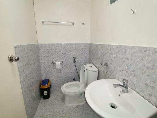 a bathroom with a white toilet and a sink at Villa Milanel Port Barton in Port Barton