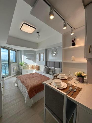 Un dormitorio con una cama y una mesa con platos. en Monaco 1011 Azure North Pampanga - Nuliv en Maimpis